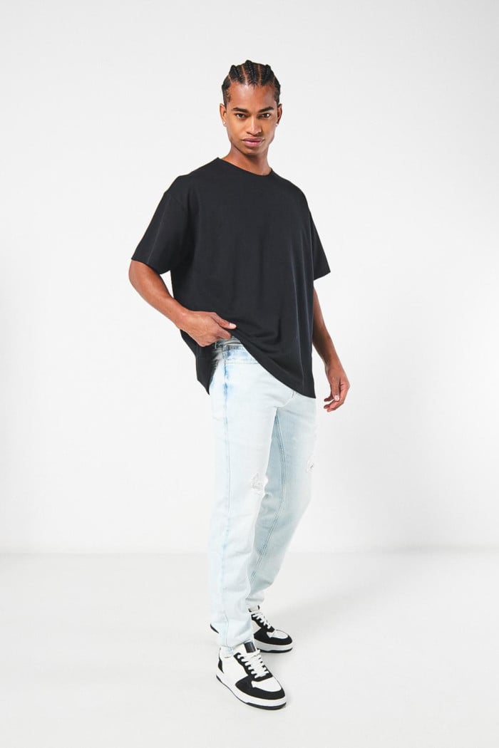 Jean azul claro slim con desgastes, rotos y tiro bajo